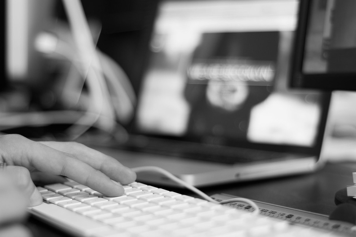 Personne tapant sur un clavier d'ordinateur dans un environnement de bureau professionnel