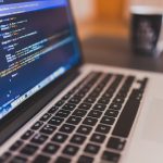 Écran d'ordinateur portable affichant du code source avec syntaxe colorée en bleu