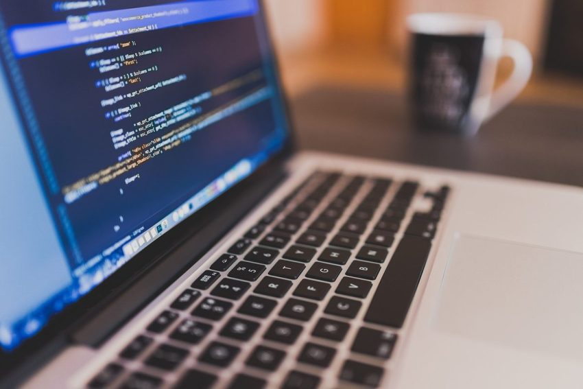 Écran d'ordinateur portable affichant du code source avec syntaxe colorée en bleu